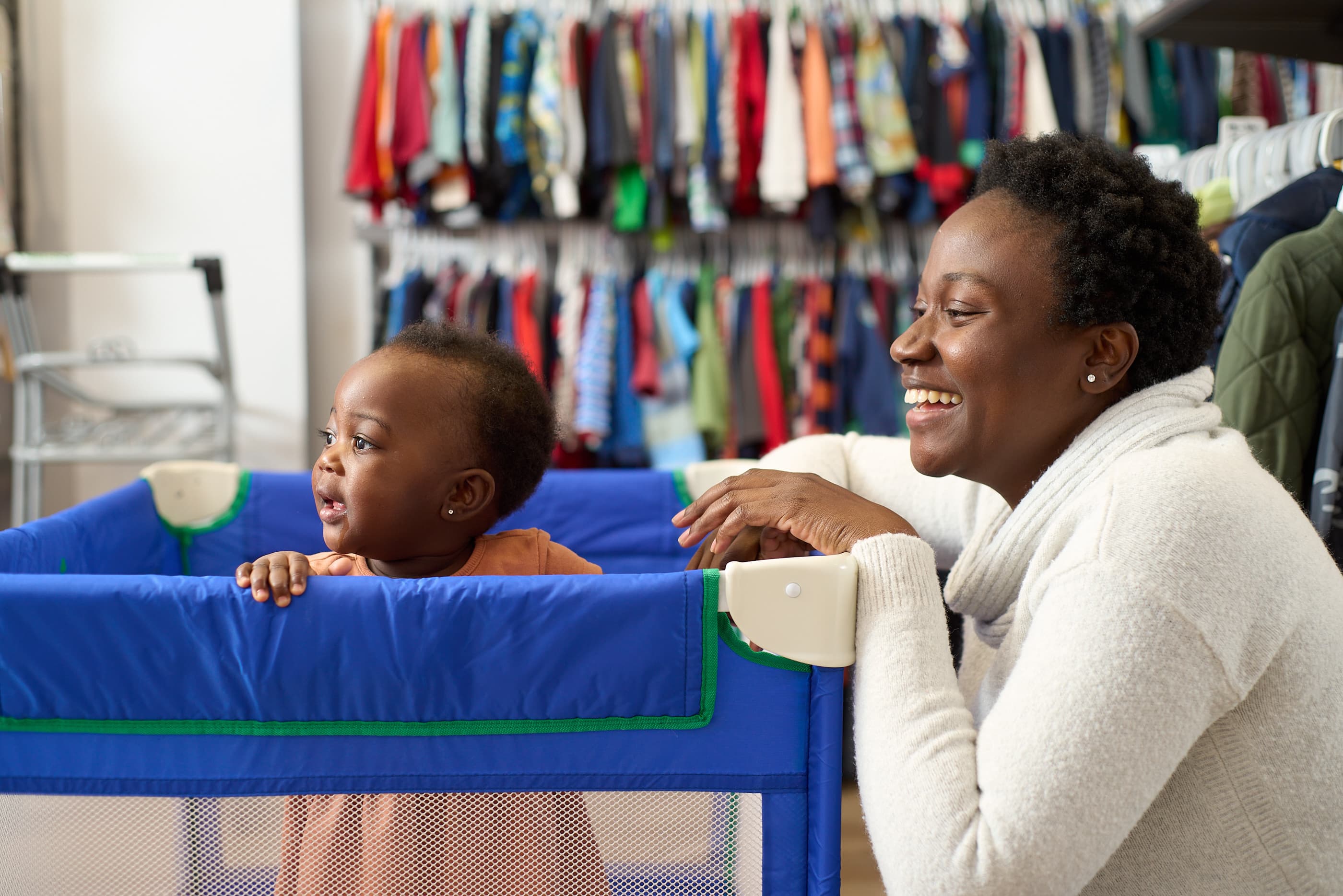A mother smiling beside her baby at the boutique